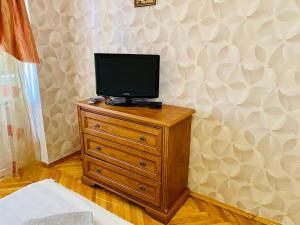 キーウにあるKvartira vozle metro Darnitcaの室内の木製ドレッサーのテレビ付