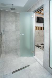 a bathroom with a shower with a glass door at cactus suites in Faliraki