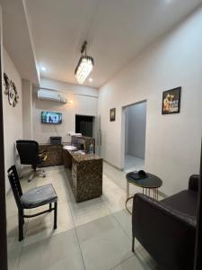 a living room with a couch and a desk and a television at Wellawing Residency in Ludhiana