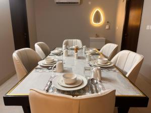 una mesa de comedor con sillas blancas alrededor en Celesto Luxury Residences by Chakola’s Hospitality en Trichūr