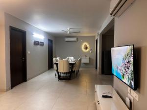 a living room with a dining table and a television at Celesto Luxury Residences by Chakola’s Hospitality in Trichūr