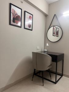 Habitación con escritorio, silla y espejo. en Celesto Luxury Residences by Chakola’s Hospitality en Trichūr