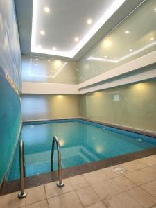 a large swimming pool in a building with at Celesto Luxury Residences by Chakola’s Hospitality in Trichūr