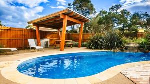 a swimming pool with a gazebo in a backyard at Island Oasis in Cowes