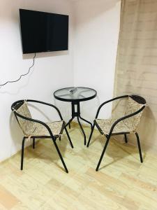 duas cadeiras e uma mesa com uma televisão na parede em DIANA'S House em Tbilisi