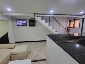 een kamer met een trap met een tv aan de muur bij THE NEST in Pattaya