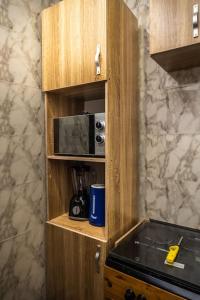einen Holzschrank mit einer Mikrowelle in der Küche in der Unterkunft Elegant 1-Bed With Unlimited Internet + 24hrs POWER in Lagos