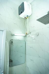 a bathroom with a mirror and a camera on the wall at Elegant 1-Bed With Unlimited Internet + 24hrs POWER in Lagos