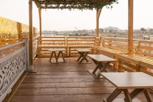 ein Restaurant mit Bänken und Tischen auf einer Terrasse in der Unterkunft Elegant 1-Bed With Unlimited Internet + 24hrs POWER in Lagos