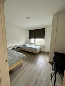 een kamer met 2 bedden en een raam bij Vakantiehuis Brug24 in Lanaken
