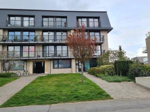 an apartment building with a tree in front of it at Homestay Gent-Merelbeke self check-in service in Ghent