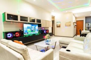 a living room with two couches and a flat screen tv at the time poolvilla3 in Jomtien Beach