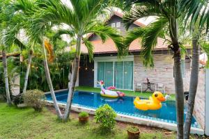 uma casa com uma piscina com dois patos de borracha em the time poolvilla3 em Praia de Jomtien