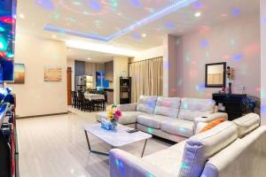 uma sala de estar com um sofá e uma mesa em the time poolvilla3 em Praia de Jomtien