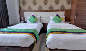 two beds sitting next to each other in a room at Treebo Rushi Grand, 1 km to Rushikonda Beach in Visakhapatnam +22 photos