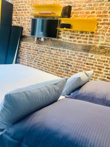 リールにあるMy Little Home - Le Vieux Lille de Rousseauのレンガの壁の客室内のベッド2台