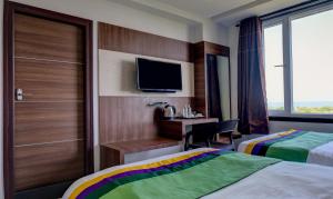 a hotel room with two beds and a tv at Treebo Trend Rushi Grand in Visakhapatnam