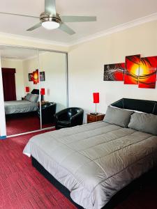 ein Schlafzimmer mit einem großen weißen Bett und einem schwarzen Stuhl in der Unterkunft Mirambeena Motel in Whyalla