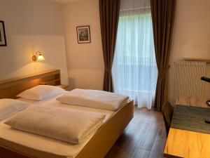 a hotel room with two beds and a window at Pension Alpenblick B&B in Vipiteno