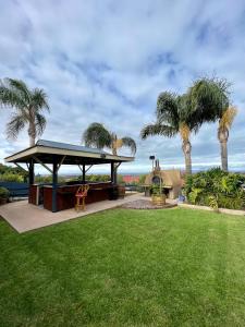 a gazebo in a yard with palm trees at Mirambeena Motel in Whyalla