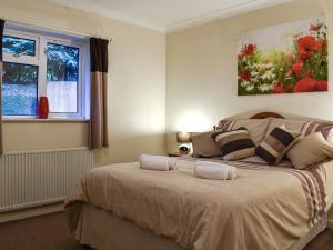 a bedroom with a large bed with two pillows at Gwynfan Bungalow in Nantmel