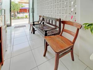 a wooden bench sitting on a tiled floor in a room at Super OYO 92433 Sirih Gading Family Guest House in Tulungagung