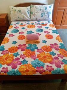 - un lit avec un motif floral et un oreiller dans l'établissement Casi Verde Panglao, à Panglao