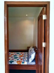 - une petite chambre avec un lit et une porte en verre dans l'établissement Casi Verde Panglao, à Panglao