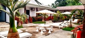 une terrasse avec une table, des chaises et un parasol dans l'établissement Casi Verde Panglao, à Panglao