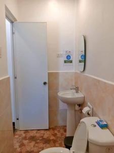 La salle de bains est pourvue de toilettes blanches et d'un lavabo. dans l'établissement Casi Verde Panglao, à Panglao