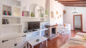 a living room with a fireplace and a tv at Casa Elena de Benagalbon Rincon de la Victoria by Ruralidays in Rincón de la Victoria