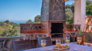 a table with wine glasses in front of a fireplace at Casa Elena de Benagalbon Rincon de la Victoria by Ruralidays in Rincón de la Victoria