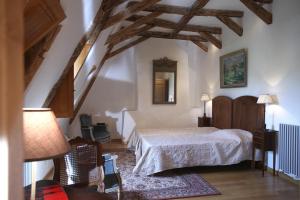 a bedroom with a bed in a room with wooden ceilings at Maison des Sarrasins in Beynac-et-Cazenac