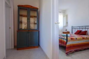 a bedroom with a blue cabinet next to a bed at Villa Esperanza Torre Specchia in Torre Specchia Ruggeri