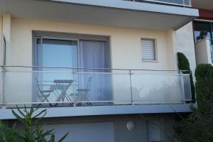 a balcony with two chairs and a table on it at Appartement sur le port d'Arcachon proche plages in Arcachon