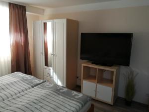 1 dormitorio con TV de pantalla plana y 1 cama en Ferienwohnung Liss, en Timmendorfer Strand