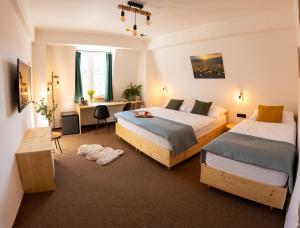 a hotel room with two beds and a desk and a desk at Hotel Rehavital in Jablonec nad Nisou
