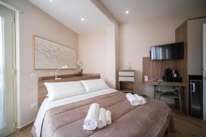 1 dormitorio con 1 cama grande y toallas blancas. en ESPERIA B&B, en Oliveri