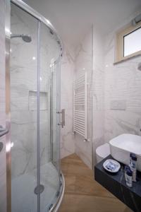 a bathroom with a glass shower and a sink at ESPERIA B&B in Oliveri