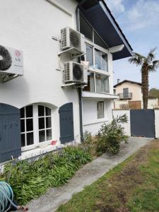 ein weißes Haus mit zwei Klimaanlagen darauf in der Unterkunft Appartement 5 personnes avec piscine 60m2 in Le Barp