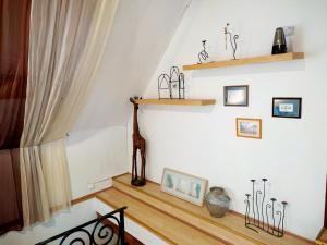 a room with a staircase with wooden floors and shelves at MonAmi Art Apartman in V&aacute;c