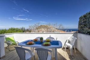 uma mesa azul com pratos de comida numa varanda em Sole e Mare 2 em Castelsardo