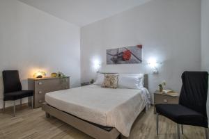 um quarto com uma cama grande e 2 cadeiras em Sole e Mare 2 em Castelsardo