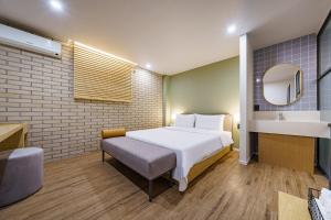 a bedroom with a white bed and a sink at Hotel Yaja Changwon Myeongseo in Changwon