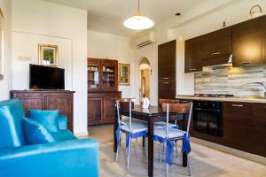 a kitchen with a dining room table and blue chairs at Casa Rita in Castiglione della Pescaia