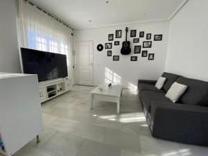 a living room with a couch and a flat screen tv at PINAR 10 in Chiclana de la Frontera