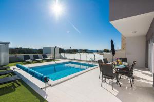 a backyard with a pool and a table and chairs at Vila Nena in Vodice