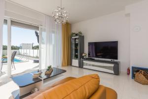 a living room with a couch and a tv at Vila Nena in Vodice