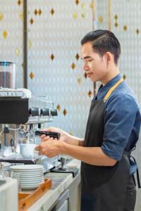 Un jeune homme dans une cuisine préparant la nourriture dans l'établissement Won Majestic Hotel Cambodia, à Sihanoukville