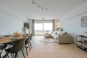 - un salon avec une table et un canapé dans l'établissement Bright apartment with beautiful sea view, à Middelkerke